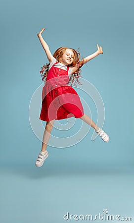 Happy redhair girl isolated on blue studio background. Looks happy, cheerful, sincere. Copyspace. Childhood, education Stock Photo