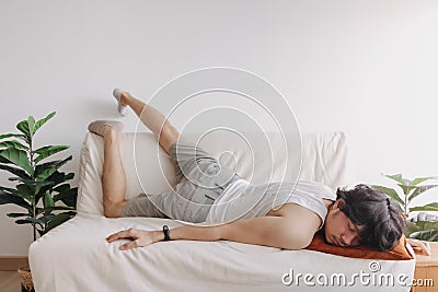 Weird and funny sleep pose of man in his apartment in boring day off. Stock Photo