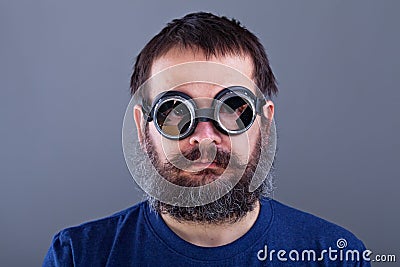 Weird guy with matted hair and large beard wearing broken welding goggles Stock Photo