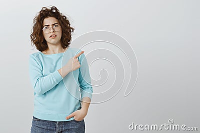 Weird things happen in that direction. Indoor shot of shocked and confused attractive caucasian woman in glasses and Stock Photo