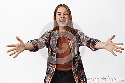 Welcome. Hostile happy girl extends hands in warm welcome, smiling and laughing greeting say hello, reaching arms for Stock Photo