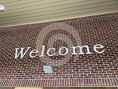 Welcome letters spelled on a brick wall white letters Stock Photo