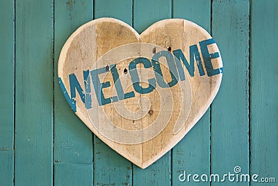 Welcome message wooden heart on turquoise painted background Stock Photo