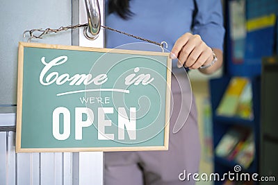 `Come in WE`RE Open` on cafe or restaurant hang on door at entrance. Stock Photo