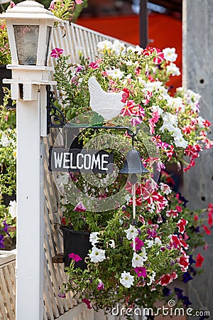 Welcome panel, black bell and flowers at hotel entrance Stock Photo