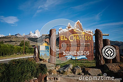 Welcome sign with emblem of El Chalten - capital of trekking in Patagonia, Argentina. Summit of Mount Fitz Roy is on left Editorial Stock Photo