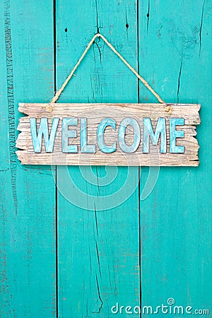 Welcome sign hanging on teal blue wood door Stock Photo