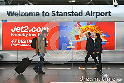 Welcome sign in London Stansted Airport with travellers passing by Editorial Stock Photo