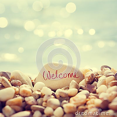 Welcome Text Written on the Stone at Beach Stock Photo