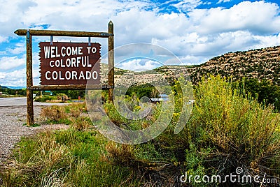 Welcome to Colorful Colorado Sign next to big Yellow Wild Bush Stock Photo