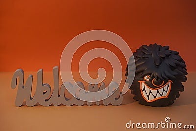 WELCOME wood inscription and shaggy hungry monster with huge teeth copyspace. Humorous invitation. April Fools Day joke Stock Photo