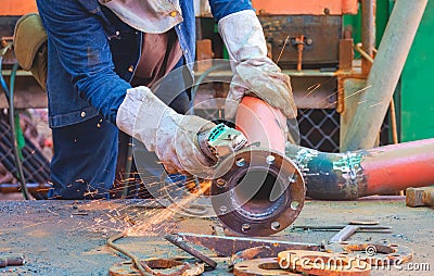 Welder hand using electric grinder machine to polishing steel pipe for improving oil pipeline system work in tanker ship Stock Photo