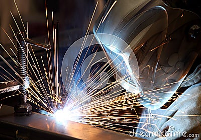 A welder joining two pieces of metal together. Stock Photo