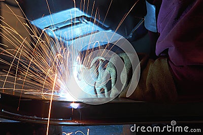 A welder joining two pieces of metal together. Stock Photo