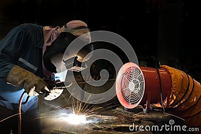 Welder repairing surface by shield metal arc welding Stock Photo