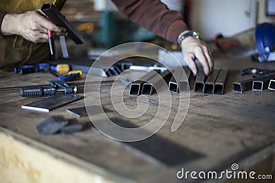 Welder selects tools and pre-cut steel parts. Stock Photo