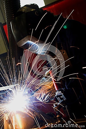 Welder welding a metal part Stock Photo