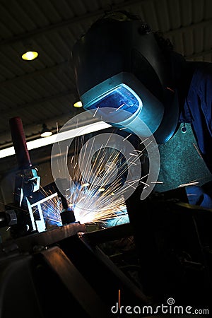 Welder welding a metal part Stock Photo