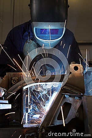 Welder welding a metal part Stock Photo