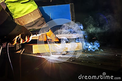 Welder is welding with shielded metal arc welding process to steel materials. Shielded metal arc (SMAW) Stock Photo