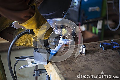 Welder welding steel base for new stool. Stock Photo