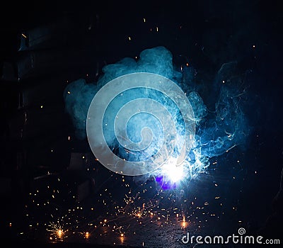 Welder welds metal parts, many sparks and fumes, welding, welding arc, bright flash, close-up, welding arc Stock Photo