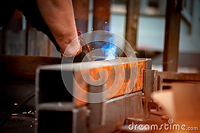 Welder welds two iron bars to each other Stock Photo