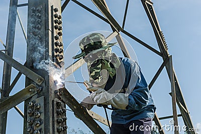 Welder work at high Electric high voltage pole 230 Kv. Editorial Stock Photo