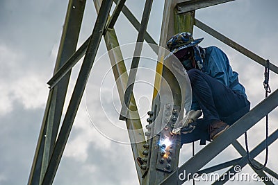 Welder work at high Electric high voltage pole 230 Kv. Editorial Stock Photo