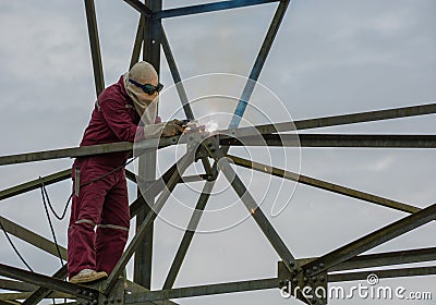 Welder work at high Electric high voltage pole 230 Kv Stock Photo