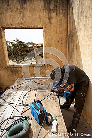 Welder at work in old house in Africa Editorial Stock Photo