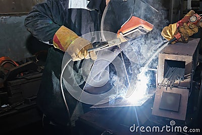 Welder in workshop conditions sample weld from sheet metal to un Stock Photo