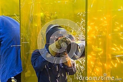 The welding craftsman grinding the steel tube Stock Photo