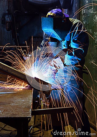 Welding worker in dark facotry Stock Photo