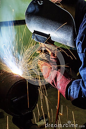 Welding worker doing welding at pipe Stock Photo