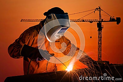 Welding worker welding steel structure with construction site Stock Photo