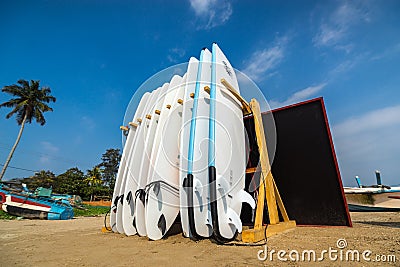 WELIGAMA, SRI LANKA - JANUARY 12 2017: Set of different color surf boards in a stack by ocean.WELIGAMA, SRI LANKA. Surf boards on Editorial Stock Photo