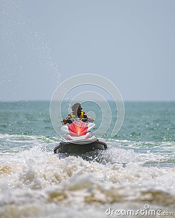 Young handsome jet ski rider in action, moving swiftly on the ocean Editorial Stock Photo