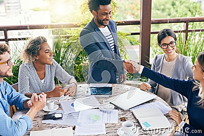 Well done on your outstanding contributions to the company. businesspeople shaking hands during a meeting outdoors. Stock Photo