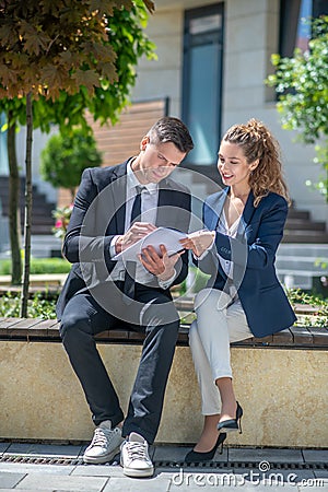 Well-dressed male client signing the contract, female broker looking pleased Stock Photo