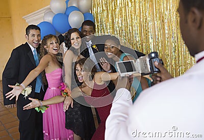 Well-dressed teenagers posing for video camera at school dance Stock Photo