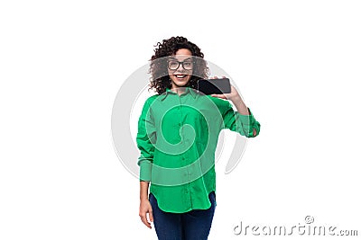 well-groomed young female marketing employee with black hair dressed in a green shirt showing a screen of a mobile phone Stock Photo