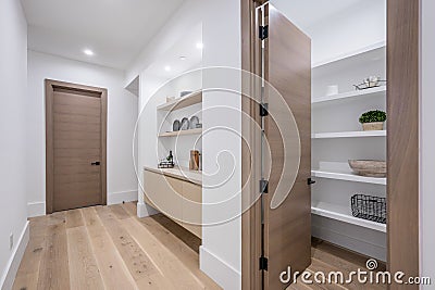 a long hallway with light wood floors and shelves full of items Editorial Stock Photo