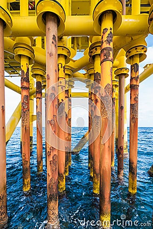 Well slot and casing of production tubing at drain deck of oil and gas wellhead remote platform. Stock Photo