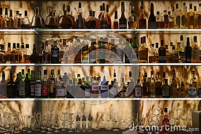 Well stocked bar with various alcoholic bottles and glasses Editorial Stock Photo