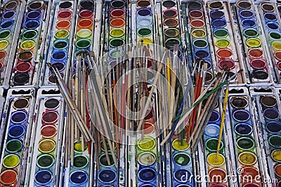 Well-used Artist Paintbrushes Arrayed Across Colorful Watercolor Pans Stock Photo