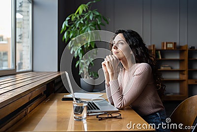 Wellbeing at work. Young dreamy female employee enjoying good window view while working in office Stock Photo