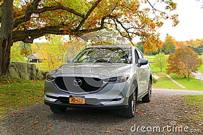 Wellesley Island, New York, U.S.A - October 25, 2019 - A silver Mazda CX-5 SUV surrounded by fall foliage Editorial Stock Photo