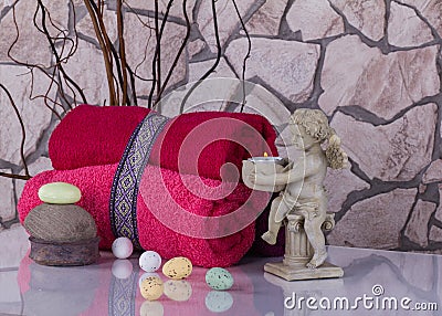 Wellness Easter still life with red touwels, eggs and angel candlestick. Stock Photo