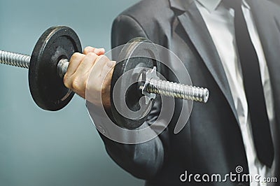 Wellness, healthy concepts. Businessman lifting dumbbell at office. Stock Photo